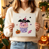 Tableau punch needle cupcake cerise et chauve-souris tenu en main pour montrer sa taille