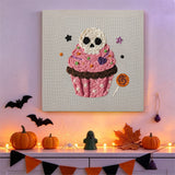Tableau punch needle cupcake rose au crâne accroché au mur dans une déco d'Halloween