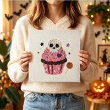 Tableau punch needle cupcake crâne tenu en main pour montrer sa taille