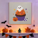 Tableau punch needle cupcake fantôme orange et violet accroché au mur dans une déco d'Halloween