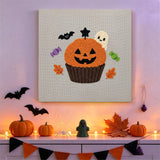 Tableau punch needle cupcake potiron accroché au mur dans une déco d'Halloween