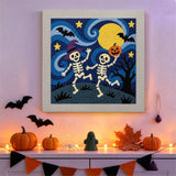 Tableau punch needle squelettes dansants accroché au mur dans une déco d'Halloween