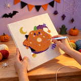 Broderie punch needle en cours, aiguille en main, sur la toile du donut citrouille souriant