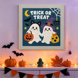 Tableau punch needle duo de fantômes déguisés accroché au mur dans une déco d'Halloween
