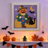 Tableau punch needle épouvantail et chat noir accroché au mur dans une déco d'Halloween