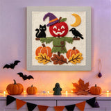 Tableau punch needle épouvantail et chat noir accroché au mur dans une déco d'Halloween