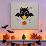 Tableau punch needle chauve-souris à l'étoile accroché au mur dans une déco d'Halloween