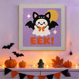 Tableau punch needle fantôme ailé accroché au mur dans une déco d'Halloween
