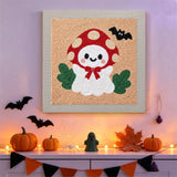Tableau punch needle fantôme amanite accroché au mur dans une déco d'Halloween