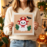 Tableau punch needle fantôme champignon tenu en main pour montrer sa taille