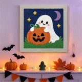 Tableau punch needle fantôme et citrouille accroché au mur dans une déco d'Halloween