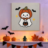 Tableau punch needle fantôme capuche accroché au mur parmi des décorations d'Halloween