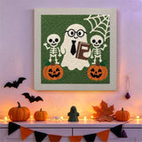 Tableau punch needle fantôme à cravate accroché au mur dans une déco d'Halloween
