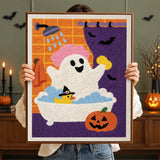 Tableau punch needle fantôme au bain tenu en main pour montrer sa taille