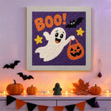 Tableau punch needle fantôme farceur au seau citrouille accroché au mur dans une déco d'Halloween