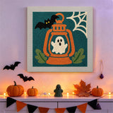 Tableau punch needle fantôme dans sa lanterne accroché au mur dans une déco d'Halloween