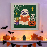 Tableau punch needle fantôme lecteur accroché au mur dans une déco d'Halloween