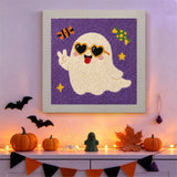 Tableau punch needle fantôme à lunettes cœur accroché au mur dans une déco d'Halloween