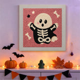 Tableau punch needle fantôme osseux accroché au mur dans une déco d'Halloween