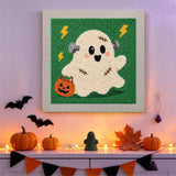 Tableau punch needle fantôme recousu accroché au mur dans une déco d'Halloween