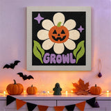 Tableau punch needle fleur citrouille au mur d'une pièce décorée pour Halloween