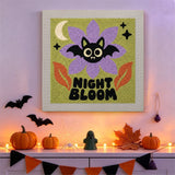 Tableau punch needle fleur et chauve-souris accroché au mur dans une déco d'Halloween