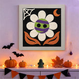 Tableau punch needle fleur momie au mur d'une pièce décorée pour Halloween