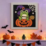 Tableau punch needle grenouille sorcière accroché au mur dans une déco d'Halloween