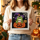 Tableau punch needle grenouille balai tenu en main pour montrer sa taille