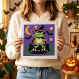 Tableau punch needle grenouille et chat noir tenu en main pour montrer sa taille