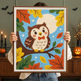 Tableau punch needle hibou d'automne terminé tenu en main pour montrer sa taille