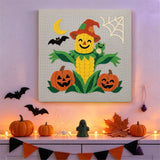Tableau punch needle épi de maïs épouvantail accroché au mur dans une déco d'Halloween