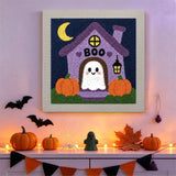 Tableau punch needle maison hantée accroché au mur dans une déco d'Halloween
