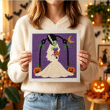 Tableau punch needle mariée monstre tenu en main pour montrer sa taille