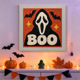 Tableau punch needle masque hurlant accroché au mur dans une déco d'Halloween