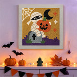 Tableau punch needle momie et citrouille accroché au mur dans une déco d'Halloween