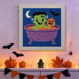 Tableau punch needle monstre au bain accroché au mur dans une déco d'Halloween