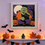 Tableau punch needle monstre vert et chat noir accroché au mur dans une déco d'Halloween