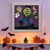 Tableau punch needle monstre à la lanterne accroché au mur dans une déco d'Halloween