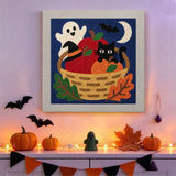 Tableau punch needle chat dans son panier accroché au mur dans une déco d'Halloween
