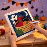 Broderie punch needle en cours sur le panier en osier et le chat noir, aiguille en main