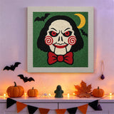 Tableau punch needle pantin aux joues en spirale accroché au mur dans une déco d'Halloween