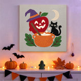 Tableau punch needle pomme et chaudron accroché au mur dans une déco d'Halloween