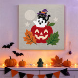 Tableau punch needle pomme et fantôme accroché au mur dans une chambre décorée pour Halloween