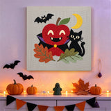 Tableau punch needle pomme vampire accroché au mur dans une déco d'Halloween