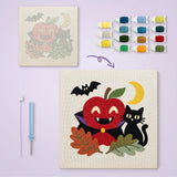 Toile imprimée numérotée posée près du tableau punch needle pomme vampire terminé
