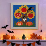 Tableau punch needle pommier hanté accroché au mur dans une déco d'Halloween