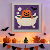 Tableau punch needle potiron au bain accroché au mur parmi des décorations d'Halloween