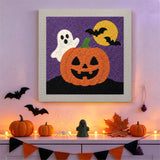 Tableau punch needle citrouille et fantôme accroché au mur dans une déco d'Halloween