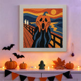 Tableau punch needle citrouille hurlante accroché au mur dans une déco d'Halloween
